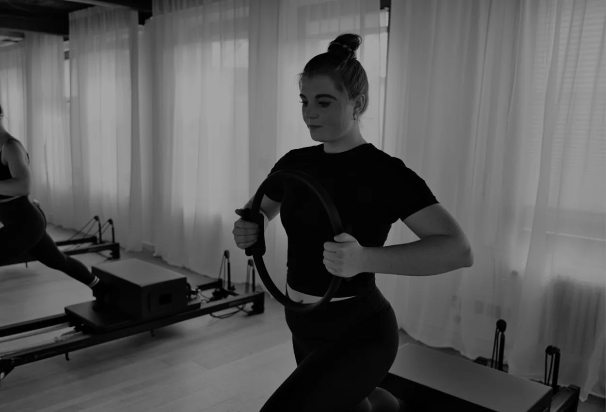Konzentriertes Training mit Pilates-Ring am Reformer bei olia